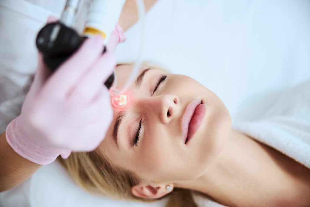 A woman is lying down and receiving her treatment for laser resurfacing in Oklahoma City.