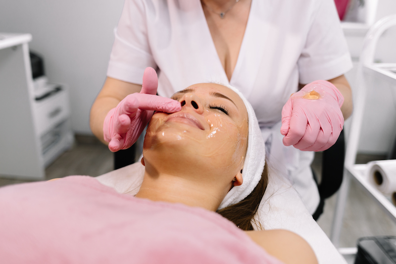 A young woman is lying down for a facial treatment in addition to laser resurfacing in Oklahoma City